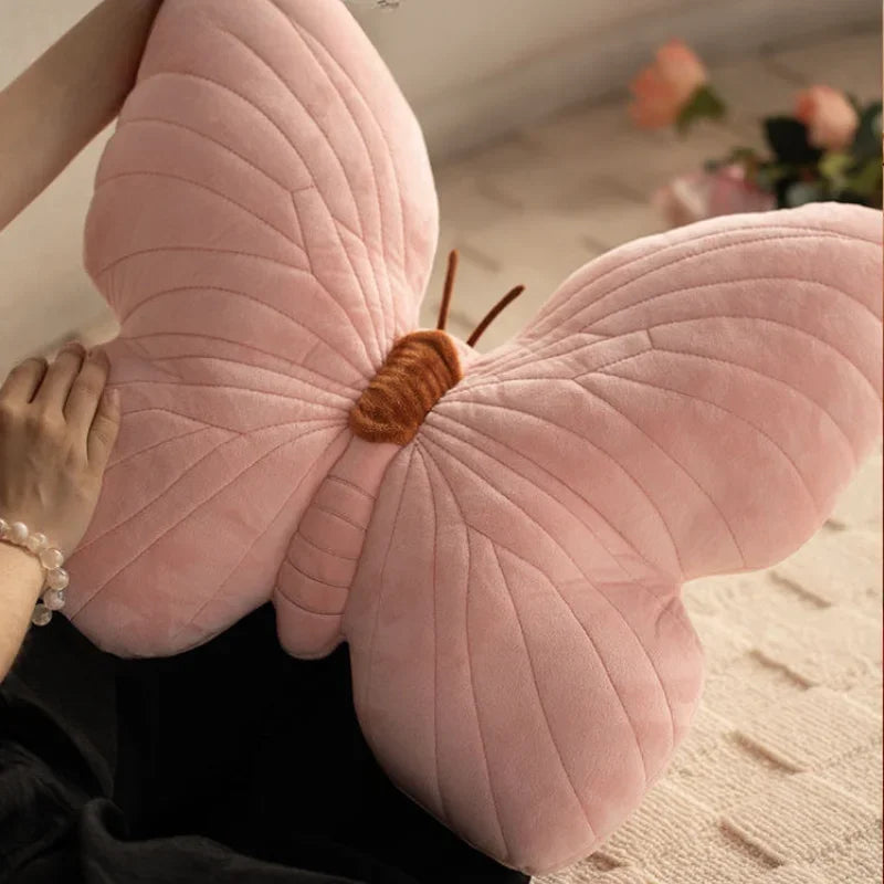 A plush pink velvet pillow shaped like a butterfly