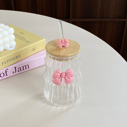 Clear glass tumbler with wooden lid and pink bow
