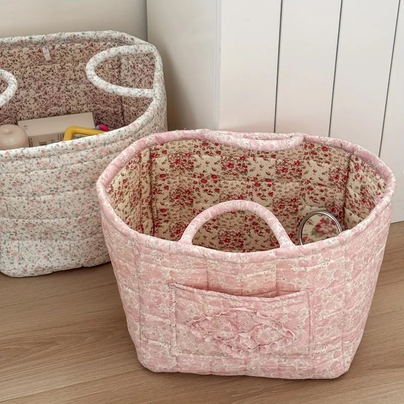 Two fabric storage baskets with floral patterns on a wooden floor.