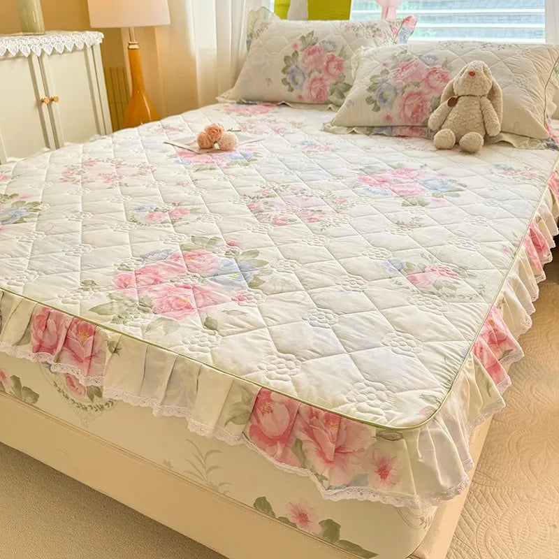 A floral style fitted mattress cover in a quilted design with lace details