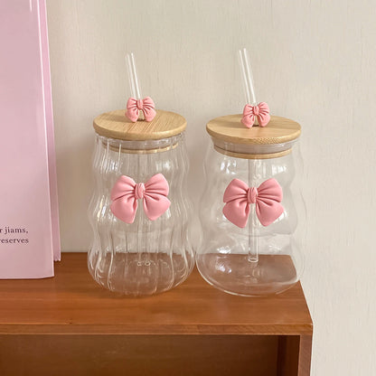 Two clear jars with wooden lids and pink bow