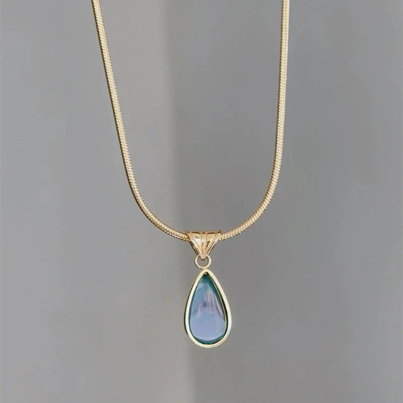 gold necklace with blue pendant 