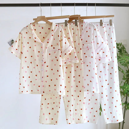 A set of women's pajamas with short sleeves, long pants, and shorts, featuring a pattern of red and pink hearts.