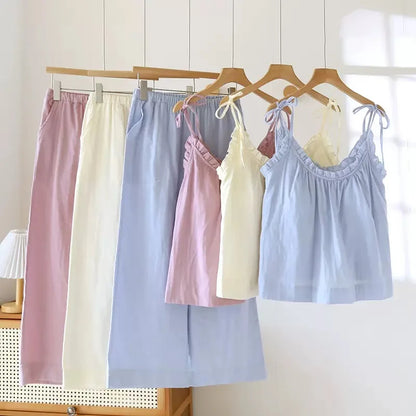 Set of pastel-colored dresses hanging on a rack against a white wall.